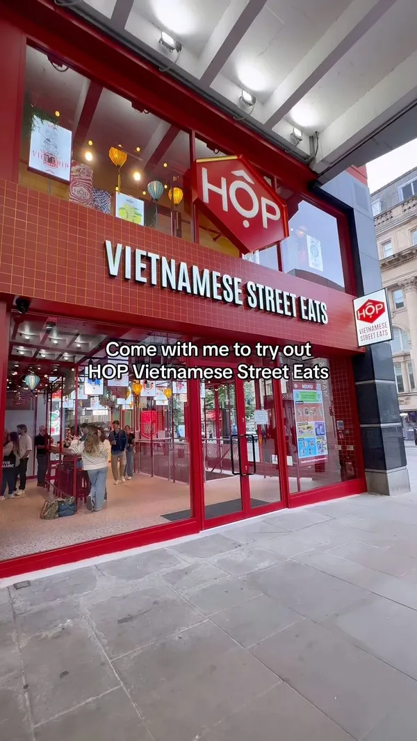 This video showcases HOP Vietnamese Street Eats, a new restaurant in Manchester. The video takes viewers on a tour of the establishment, highlighting its vibrant decor, digital ordering system, and menu items.  Dishes shown include rice boxes, noodle soups, salads, banh mi, fried chicken, and various desserts and drinks. Dietary information such as vegetarian options is shown on the menu screens. The video emphasizes the restaurant's fun atmosphere and quirky aesthetic.