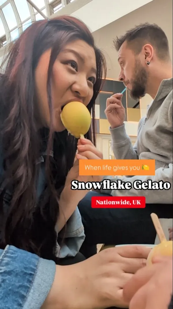 The video showcases Snowflake Gelato at Meadowhall. It features people, including a child, a woman, and a man, eating different gelato products on sticks, specifically the yellow 'Snow Lemon' and a chocolate-covered stick with green drizzle ('Dubai Chocolate Stick'). The video also includes shots of the gelato counter display, highlighting various products and signage for 'Take Home Tubs' and 'Dubai Chocolate Stick'.
