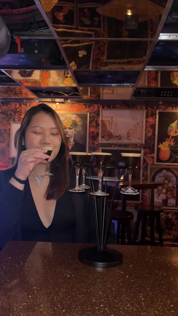 This video showcases The Escapologist, a quirky cocktail bar in Covent Garden, London.  It highlights the bar's unique atmosphere, inspired by an 1899 secret society, featuring dim lighting, eclectic artwork, and private rooms. The video features various cocktails, including a happy hour deal (two cocktails for £12), and a Kahula sharer tree.  The presenter explores different areas of the bar, and the overall vibe is upbeat and fun.