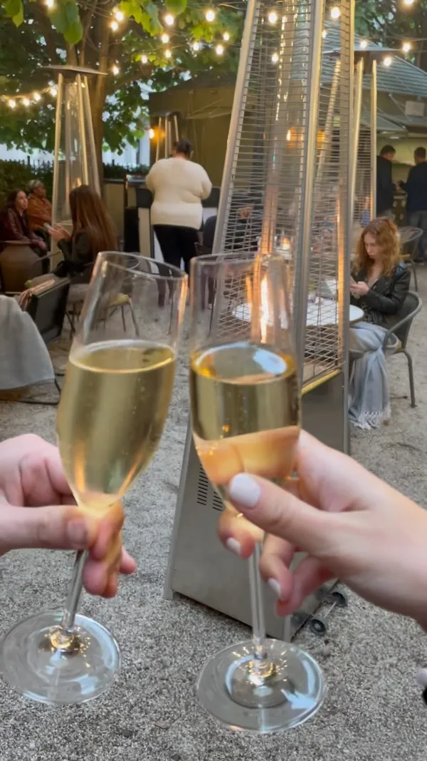 This video showcases La Terraza, an outdoor restaurant space. It highlights various tapas, including cheeses, cured meats, and sandwiches.  The video also features champagne and cocktails. The presentation emphasizes the inviting atmosphere of the restaurant and the visually appealing nature of the food and drinks. No specific dietary information is provided.