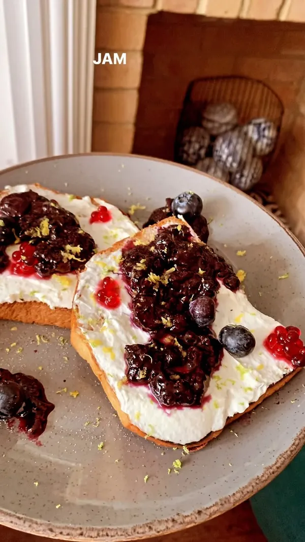 The video showcases a brunch experience at The Little Yellow Door in Notting Hill. It features the restaurant's quirky interior, including colorful sofas and a fish tank. The food and drink items shown include an Aperol Spritz, NYC Style Breakfast Bun (sausage, egg, bacon, cheese, chipotle sauce), avocado toast with smoked salmon and sweet chili jam, and toasted blueberry brioche with goat's cheese cream and lemon zest. The presentation emphasizes vibrant colors and close-ups of the food's textures. Dietary information is partially provided, mentioning the availability of vegetarian options (vegetarian brioche toast). The primary focus is showcasing the food, ambiance, and overall experience at The Little Yellow Door.