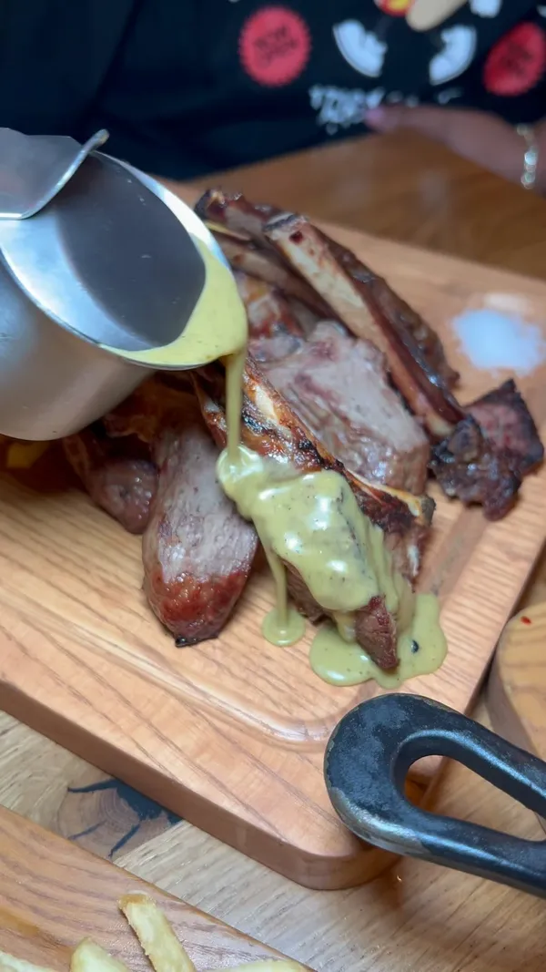 The video showcases Swiss Butter restaurant in London. It features lamb chops, steak, and salmon dishes, all served with fries and bread.  The presentation is visually appealing, with close-ups of the food and drinks. The video also highlights the restaurant's ambiance and includes shots of patrons queuing outside.  The main focus is on the food, with a positive review of both the food and drinks.  No dietary information is explicitly mentioned.