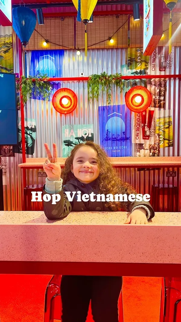 This video showcases Hop Vietnamese, a fast-casual Vietnamese restaurant located inside West One near Bond Street station in London. The video features various menu items such as rice boxes, noodle salads, Banh Mi, bubble tea, and iced coffee. The restaurant's interior is vibrant and colorful with pink and red tones. The food presentation is simple but visually appealing. There is no specific mention of dietary options, but it does state the calorie count of a meal.