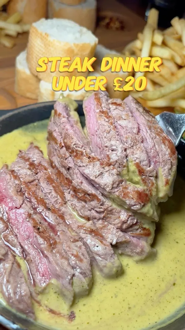 The video showcases a steak dinner at Swiss Butter restaurant in Holborn, London. The main dish features sliced steak in a green sauce, served with chips, salad, and baguette. The restaurant offers a limited menu of chicken, beef, or salmon, all served with the same sides. The video highlights the special sauce, which is described as buttery with a hint of mustard, and emphasizes how well-cooked the steak is.  The video also shows the restaurant exterior and the menu. Dietary information is not explicitly provided but may be available on the menu shown. The primary focus is on the meal presentation and the enjoyment of the food.