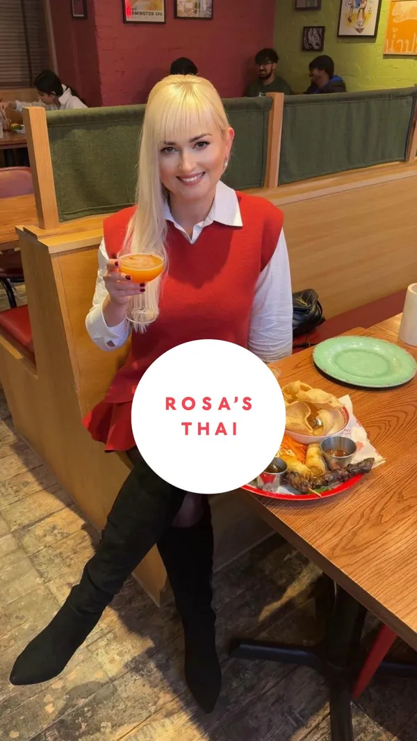 The video showcases Rosa's Thai Cafe, highlighting their lunch deal. It features various dishes: a classic platter (spring rolls, calamari, pork skewers, fried chicken, prawn crackers), chicken stir-fried noodles, chicken red curry, and cocktails (Dragon Star Martini and Lychee Ginger Spritz). The food is presented on red and teal plates, with appealing close-ups. No dietary information is explicitly mentioned. The main focus is showcasing the food and the restaurant's ambiance.