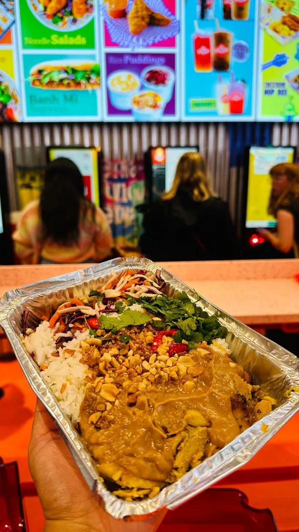 The video showcases Hop Vietnamese Kitchen's new Bond Street Station outlet. It features various food and drink items, including bubble tea, chicken satay, lemongrass chicken, chicken fillets, loaded tots, and several HOP boxes with customizable ingredients.  The presentation emphasizes vibrant colors, with pink and red accents in the restaurant decor and food packaging. Dietary information is partially given, mentioning vegetarian options. The video primarily focuses on a meal showcase, highlighting the food, drinks, and ambiance of the establishment.