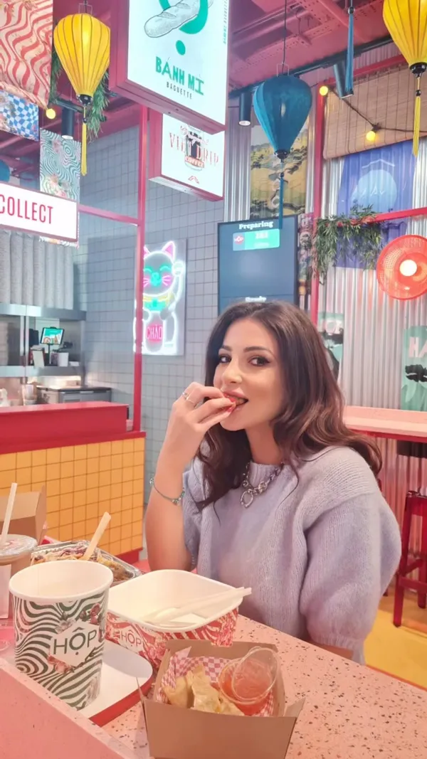 The video showcases a variety of food and drinks from Hop Vietnamese, a fast-food restaurant located in Bond Street tube station in London. The influencer tries various dishes, including chicken pho, vegetable dumplings, loaded tots, caramel chicken noodle salad, coconut chicken curry, Viet fried chicken dippers, and drinks like boba tea and traditional milk tea.  The food is presented in takeout boxes and containers. No specific dietary information is provided. The main focus is on showcasing the variety and deliciousness of the food, alongside quick shots of the restaurant's interior. 