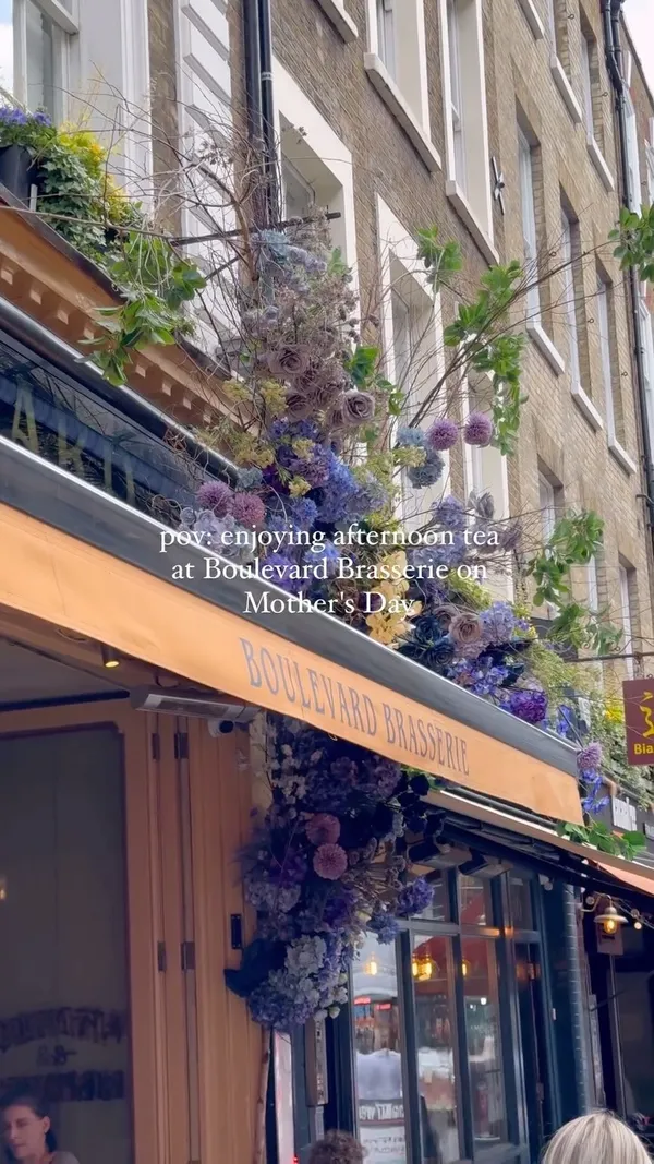 The video showcases an afternoon tea experience at Boulevard Brasserie in London on Mother's Day.  It features various pastries, sandwiches, and scones arranged on a tiered stand.  The venue is a Parisian-style brasserie with outdoor seating.  The video primarily focuses on the food presentation and the overall ambiance of the afternoon tea.