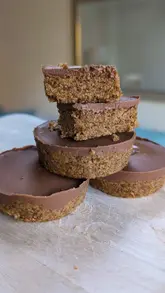 No-bake peanut butter Weetabix cups topped with melted chocolate, featuring four delicious treat cups.