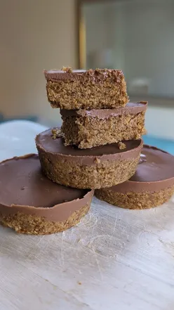 No-bake peanut butter Weetabix cups topped with melted chocolate, featuring four delicious treat cups.