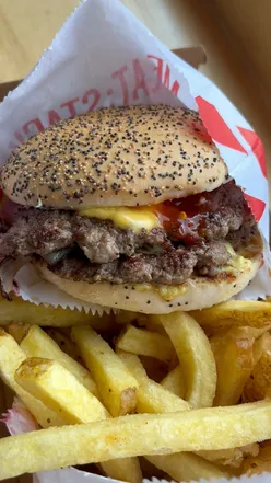 Delicious Meat Stack burgers and fries, featuring monthly specials including lamb smash and Born on the Bayou.