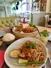 Diners enjoying bold Thai dishes and cocktails at Giggling Squid in Leamington Spa, surrounded by beautiful decor.