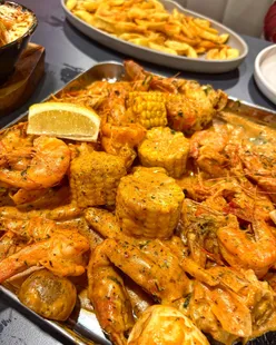 Delicious seafood boil at Jimmy's featuring lobster, prawns, crab, corn, and potatoes, perfect for sharing with friends.