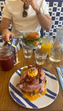 Brunch at Kozy Paris in Montmartre featuring avocado benny with bacon on brioche, a popular walk-in spot.