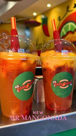 Colorful Mangonada drink with tamarind stick at Mr Mangonada in Birmingham, perfect blend of sweet, spicy, and tangy flavors.