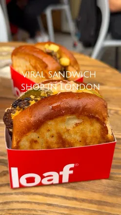 'Customers enjoying unique sandwiches at The Loaf in Clerkenwell, London, featuring steak and double smash burger.'