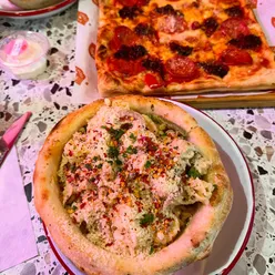 Pasta served in a pizza bowl at Lucky Mama's in Manchester, featuring Rasta pasta and diavola pizza.