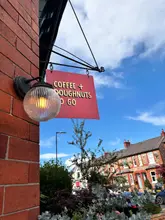 Delicious doughnuts and coffee enjoyed during a sunny dog walk at Cafe A Bloc, perfect for food lovers.
