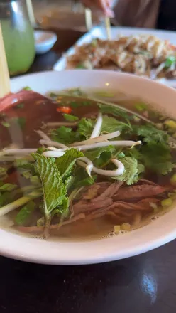 Beef brisket pho served at Pho restaurant's new St. Albans location, showcasing Vietnam's national dish in a vibrant setting.