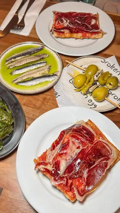 Couples enjoying a tapas date night at Broken Eggs, featuring sangria and signature dishes, while earning OpenTable rewards.