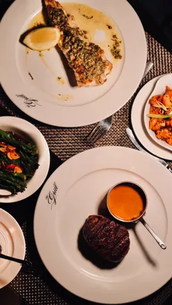 Intimate dining at The Grill at Dakota Hotel, showcasing delicious seafood and steak dishes in Edinburgh.