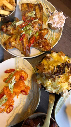 Diners enjoying a flavorful meal with lamb chops, mac and cheese, and bunny chow at Afrikana Kitchen in Manchester.