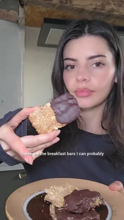 Delicious homemade breakfast bars made with oats, seeds, almond butter, and honey, ready to be sliced and coated in chocolate.