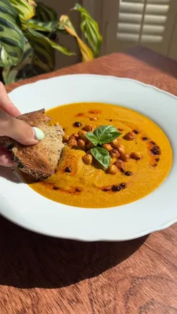 Delicious high-protein smoky sweet potato soup topped with crispy chickpeas and chili oil, perfect for cozy meals.