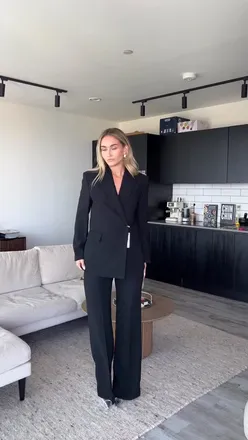 Fashion influencer showcases a classic black suit, highlighting its quality and affordability in an autumn outfit inspo.