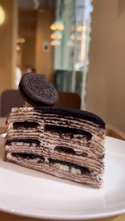 Delicious mille crêpes at Kova Patisserie in Ealing, featuring flavors like vanilla and Oreo, alongside tasty teas and coffees.