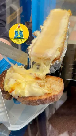 Cheese lovers enjoying raclette and Zapiekanka at The Cheese Box, an iconic old police box in Glasgow City Centre.
