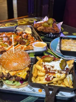 Interior of The Good Hood in Falkirk, featuring graffiti art and spacious seating for enjoying halal burgers and pizza.