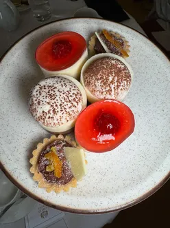 Guests enjoying a lavish murder mystery afternoon tea with cakes and scones at Lumley Castle