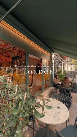 Cozy autumn café in London with matcha and coffee, showcasing warm vibes and a skilled barista.