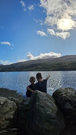 Family enjoying hot tub lodge at Loch Tay Highland Lodges, surrounded by nature and evening firepit fun.