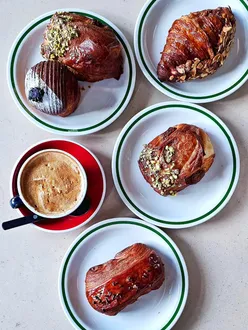 Delicious pastries and brunch dishes at Populations Bakery and Boulangerie Bon Matin, highlighting their pistachio bear claw and French toast.