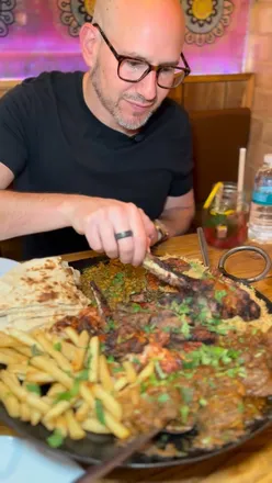 Delicious Pakistani platter at Tavah in St Albans featuring curries, lamb chops, daal, and fresh bread.