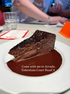 Enjoying diverse dishes at Arcade Food Hall, featuring chicken momos and chocolate torte in a vibrant setting.