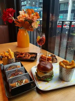 Delicious lunch spread at Canary in Leeds featuring cheeseburger, fish tacos, chicken tenders, and cocktails.