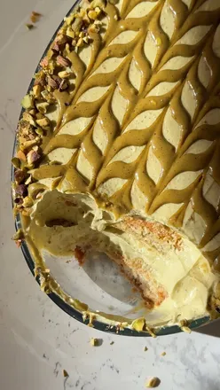 Pistachio tiramisu dessert with layers of mascarpone cream and coffee-soaked ladyfingers, topped with pistachio cream.