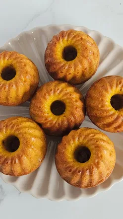 Delicious mini pumpkin bundt cakes with cream cheese frosting, perfect for Halloween dessert. Recipe on Tashcakes.