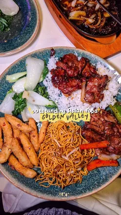 Diner enjoying a feast of Korean ribs, dim sum, and stir-fried dishes at Golden Valley, a stunning Asian restaurant in Glasgow.