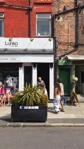 Couple enjoying a stroll on vibrant Lark Lane on a lively Friday afternoon.