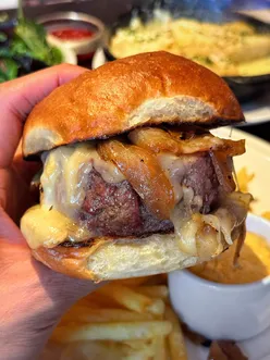 Delicious LE HAMBURGER at @juliesw11, featuring a thick burger, raclette, and fresh frites in West London.