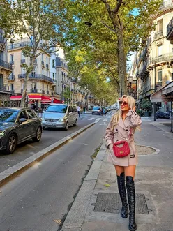 Sophie enjoying a croissant in Paris, embracing autumn fashion during her walking tour.