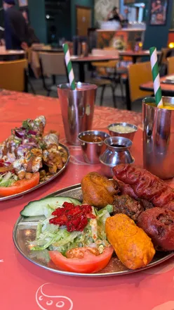Delicious small plates at The Pakora Bar, Edinburgh: golgappa, samosas, and flavorful lassis on a vibrant street food menu.