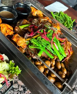 Patrons enjoying grilled meats and mixed bread at Smoke and Dough in Chelmsford, a new dining experience.