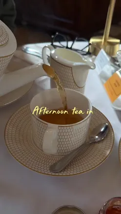 Elegant afternoon tea setup at The Pump Room in Bath, featuring scones, chandeliers, and piano music.
