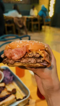 Excited diners at Sidestreet's new Bolton location celebrating with juicy smash-beef burgers and 50% off specials!