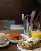 Guests enjoying a lavish hotel breakfast at Wilde Aparthotels in Cambridge, indulging in gourmet dishes and relaxation.